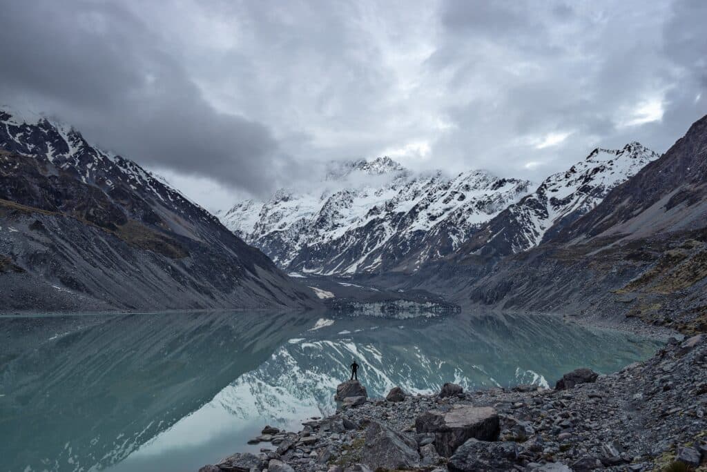 Nature positive man looking at frozen lake and mountain view - Never stop exploring ©Andy Kerr